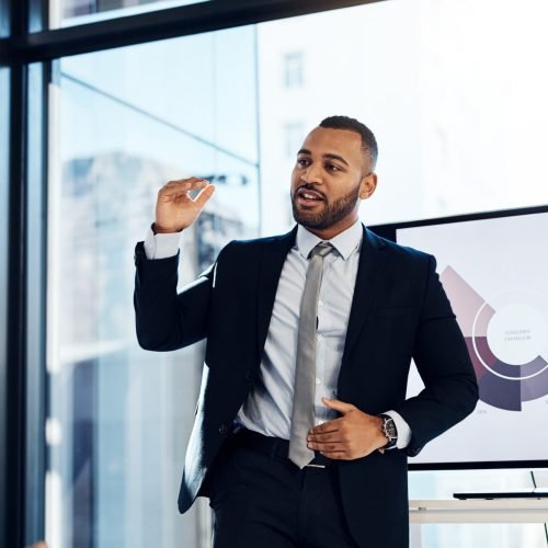Presentation, meeting and growth with a business man talking to his team in the office boardroom. Training, seminar and finance with a coach teaching staff using a graph display during a workshop.