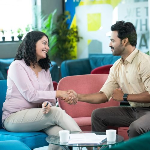 two-business-partners-shaking-hands-while-sitting-cafe